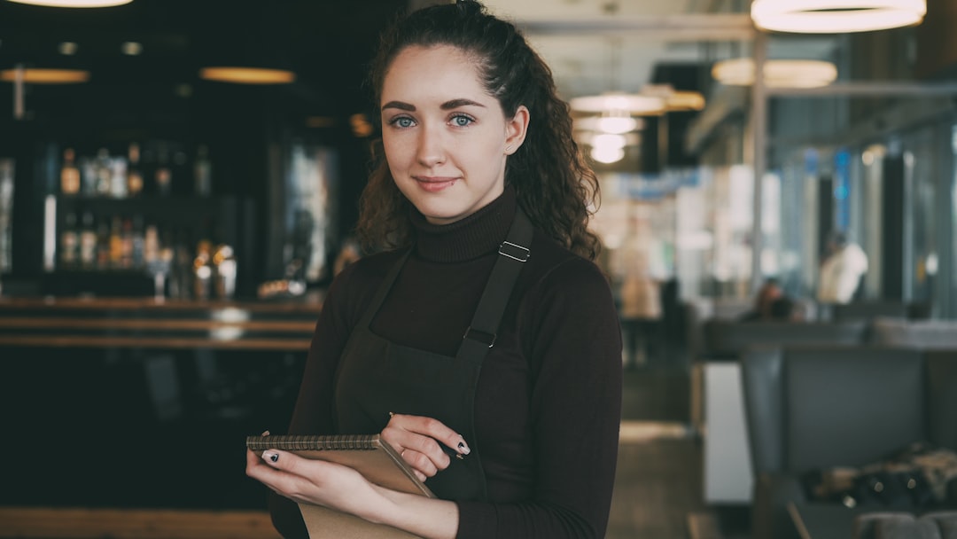 Woman in apron holding tablet in restaurant