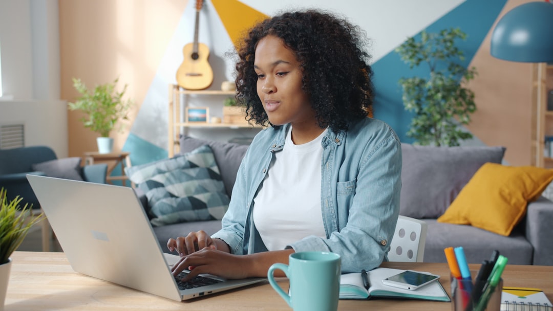 Woman working on a laptop in a cozy living room.