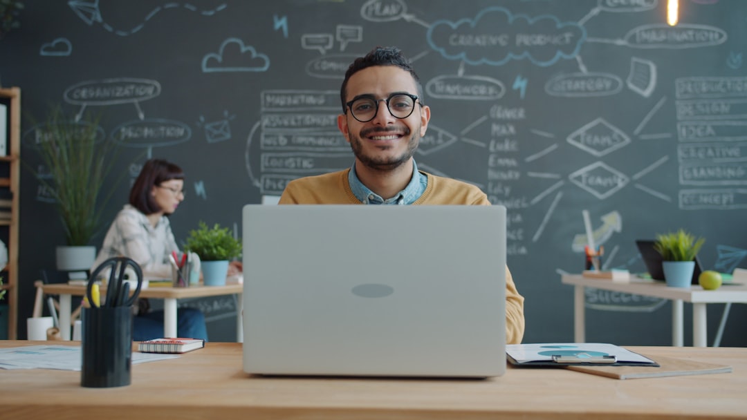 Man smiling at laptop in modern office